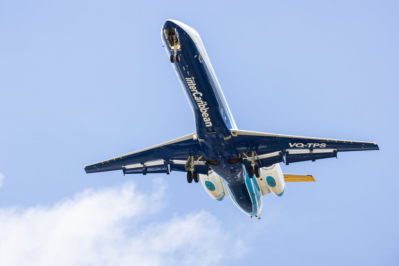 InterCaribbean airplane flying overhead against a bright blue sky in Basseterre, capturing motion and aviation excitement.